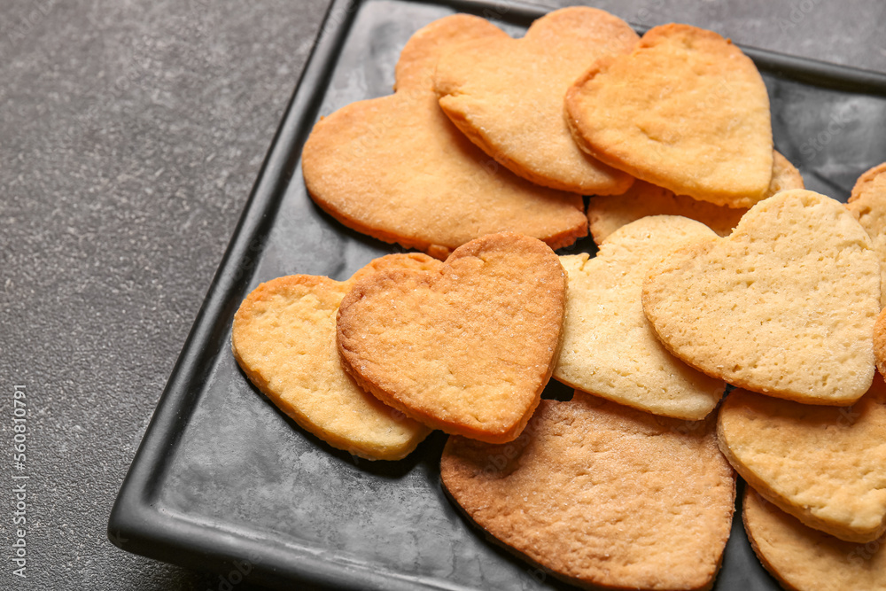 Plate with sweet heart shaped cookies on dark background, closeup. Valentines Day celebration