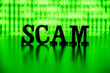 SCAM spelled out with letter tiles backlit by bright green binary code computer screen.