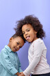 © alfa27 - happy black children posing at camera and cheerfully smiling over purple background, cute american brother and sister having fun together, showing tongue, wearing casual clothes. familt, children