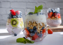 Yogurt, Chia Seeds, Blueberries, Strawberries, Raspberries, Mint, Kiwi On A Light Background
