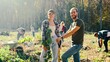 © ihorvsn - Portrait of young Caucasian happy couple of eco activists smiling to camera in park on sunny day and planing seedling of tree on field in forest or park. Outdors. Handsome man and pretty woman.