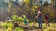 © ihorvsn - Team of environmental activists planting trees in garden at forest and taking care of nature. Outdoor. Caucasian men and women working in park with tree seedlings on sunny day.