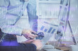 © peshkova - Double exposure of chart with businessman typing on computer in office on background. Concept of hard work.