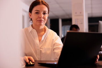 Poster - smiling employee working on laptop in office, looking at camera, marketing specialist using computer