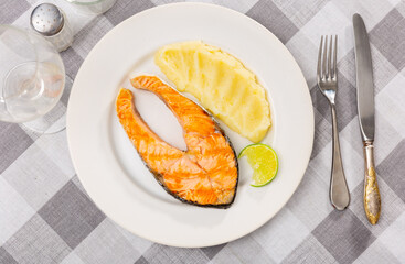 Wall Mural - Grilled salmon steak garnished with mashed potato served with lime slice ..