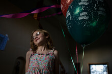 A Young Girl Smiles While Standing Next To Balloons During A Birthday Party Celebrating Her Eighth Birthday, In Breckenridge, Co