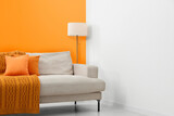 Fototapeta  - Stylish room with cosy sofa near orange wall. Interior design