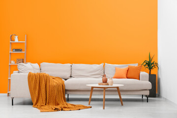 Poster - stylish sofa and coffee table in room with orange walls. interior design