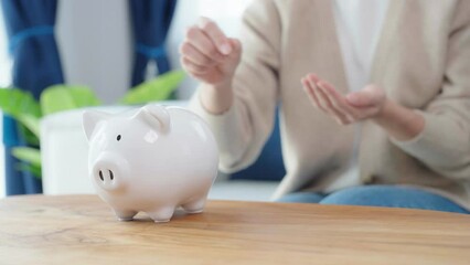 Wall Mural - Asian woman putting coin in piggy bank. Save money and investment concept