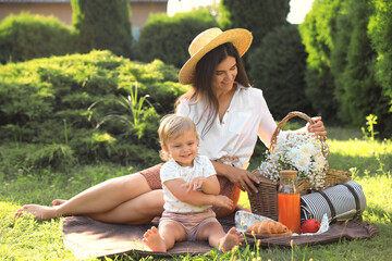 Poster - Mother with her baby daughter having picnic in garden on sunny day