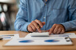 © ArLawKa - Hand of a business man using a calculator to check financial accounts, check expenditures and company budget. Female accountant calculating while working analyzing business reports at work