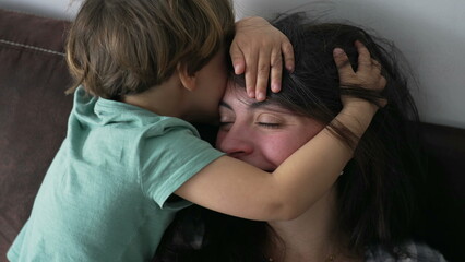 Child embracing mother. Candid little boy hugging mom head. kid covering parent face showing love and affection. Authentic family care