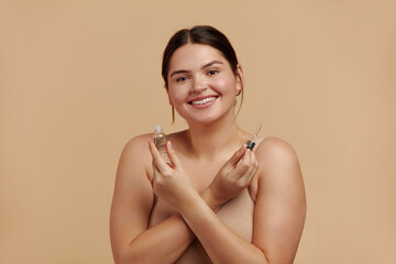 Woman Applying Serum on Face. Woman Applying Essential Oil On Facial Skin And Looking at Camera. Beautiful Model Moisturizing Derma With Natural Vitamin E, Serum Collagen And Hyaluronic Acid