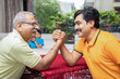 © GAJENDRRA BHATI  - Portrait of happy indian senior father and young son Arm wrestling with each other at home. closeup