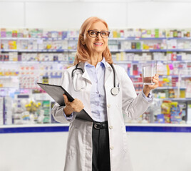 Sticker - Female doctor holding a glass of water and in a pharmacy