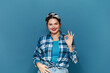 Smiling Woman Ok Gesture Isolated. Portrait of Satisfied Plus Size Girl Standing, Looking at Camera and Showing Ok Sign Gesture. Indoor Studio Shot Isolated on Blue Background 