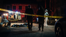 Cinematic Shot: Lieutenant Arriving At A Crime Scene, Crossing The Yellow Tape, Listening To Briefing From First Responder Officer. Detective Checking The Body Bag. Forensics Team Gathering Evidence
