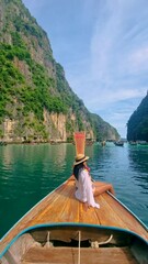 Wall Mural - Asian women in front of a Longtail boats and green blue turqouse lagoon at Pileh Lagoon Tropical Island of Koh Phi Phi Thailand