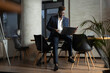 © JustLife - Portrait of successful businessman in office. Young smiling man using the laptop.