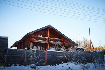 Wall Mural - Village house in winter snow scene. A snow covered tree with snow drifts at a village house in winter