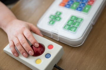 Woman with cerebral palsy works on a specialized computer mouse.