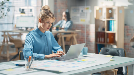Poster - Portrait of Beautiful Caucasian Woman Working on Laptop Computer at a Bright Creative Office. Young Female Manager Updating Employees' Schedules and Answering Colleagues' E.mails