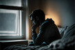 Depressed man losing his job and heartbroken sitting alone in bed near a window in dark with the low light environment, PTSD Mental health, and depression concept.psychological problem, sadness