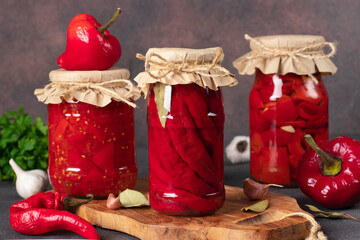 Various types of pickled peppers - chili peppers, sweet peppers with garlic and peppers in tomato sauce