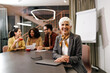 © bnenin - Portrait of a senior businesswoman, being in the meeting room with her colleagues.