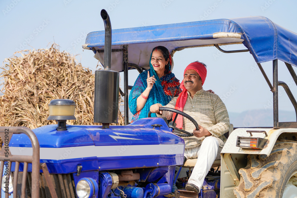 Indian farmer sitting on tractor with wife at agriculture field. Stock ...