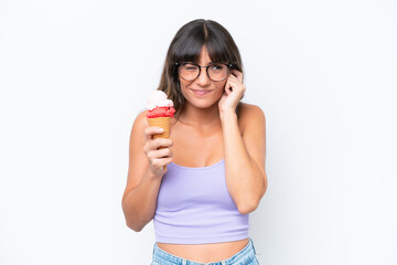 Wall Mural - Young caucasian woman with a cornet ice cream over isolated white background frustrated and covering ears