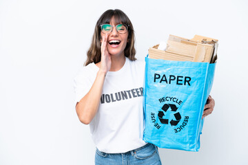 Wall Mural - Young caucasian woman holding a recycling bag full of paper to recycle isolated on white background shouting with mouth wide open