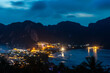 View from above. View over Ko Phi Phi Don, Thailand from the viewpoint above the town. The mountains are in silhouette as night falls and the lights are coming on.