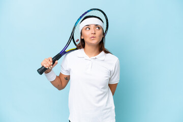 Poster - Young tennis player woman isolated on blue background and looking up