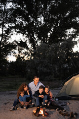 family bonfire in mountain forest. five people camping. bbq marshmallow. summer hike and camp weathe