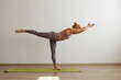 © Evrymmnt - Sporty adult woman practicing hatha yoga at home. Fit middle aged yogini doing the single leg warrior III pose variation. White wall background, copy space, close up.