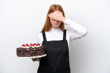 Wall Mural - Young redhead woman holding birthday cake isolated on white background covering eyes by hands. Do not want to see something