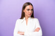 © luismolinero - Young caucasian woman isolated on purple background keeping the arms crossed