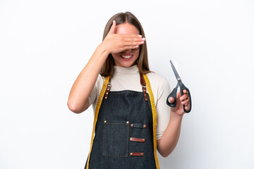 Wall Mural - Young seamstress woman isolated on white background covering eyes by hands. Do not want to see something