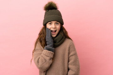 Wall Mural - Little girl with winter hat isolated on pink background with surprise and shocked facial expression