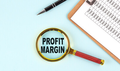 Poster - PROFIT MARGIN text on magnifier with clpboard on blue background
