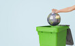 © Antonio Solano - Crop anonymous woman throwing globe into trash can
