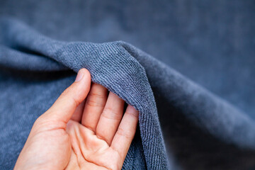 Hand holding the fabric. Women touch the fabric soft and smooth ,