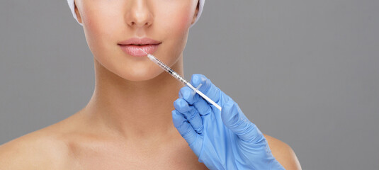 Doctor injecting in a beautiful face of a young woman. Plastic surgery concept.