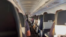 Back Of Plane Corridor Aisle. Passenger Seated Inside Airplane Traveling In Flight