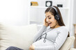 © Andrii - Photo of side view of pregnant woman with headphones.
