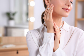 Poster - Young woman wearing elegant pearl jewelry indoors, closeup. Space or text