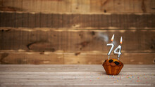 Scenery Festive Wooden Background Happy Birthday Copy Space. Anniversary Background With Number Of Burning Candles And Muffin. Beautiful Brown From Vintage Boards Background  Birthday 74