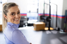 Portrait Of Happy Caucasian Fit Woman Turning And Smiling To Camera At Gym