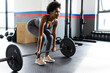 © Wavebreak Media - African american fit woman exercising and carrying weight bar at gym